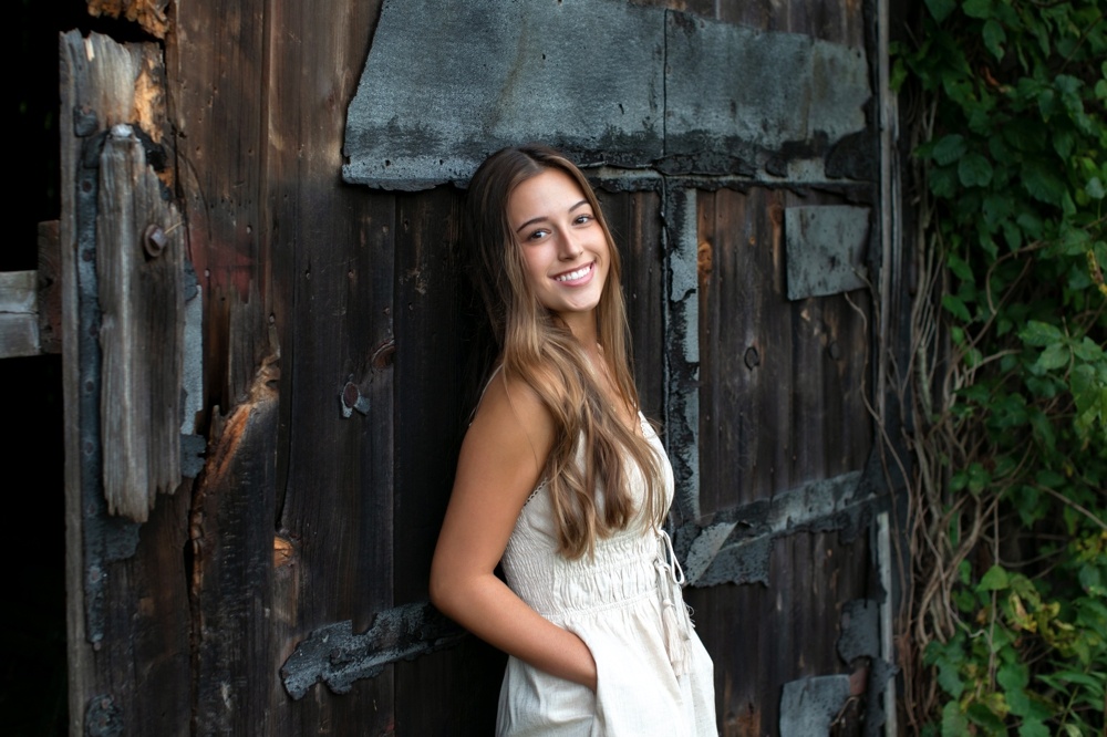 2021 ct senior portraits session leaning against old barn door at northwest park, ct 